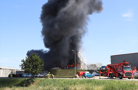 Grote brand bij betonfabriek, rookwolken zichtbaar tot in de verte