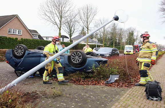 Auto onderweg naar sinterklaasviering op zijn kop op het wegdek