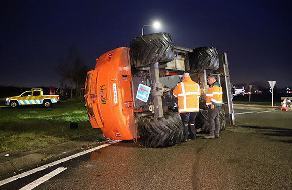 Graafmachine valt van dieplader in Geldermalsen