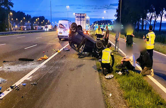 Auto over de kop bij ongeval op de A2 bij Beesd, veel glas op de weg