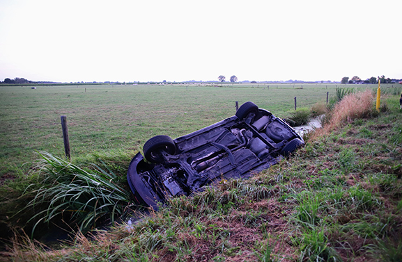 Auto op de kop in de sloot