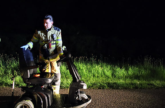 Man vast met voet onder scootmobiel in water aan de Inudatiedijk-Zuid