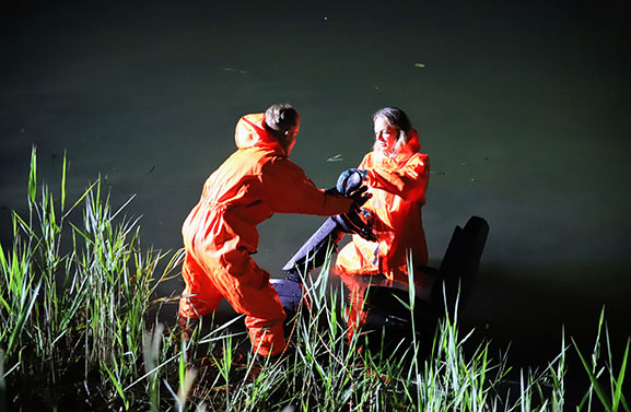 Man vast met voet onder scootmobiel in water aan de Inudatiedijk-Zuid