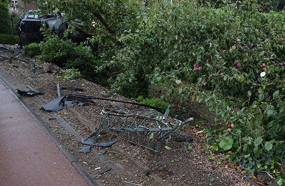 Auto ramt hekwerk en komt in tuin op zijkant tot stilstand