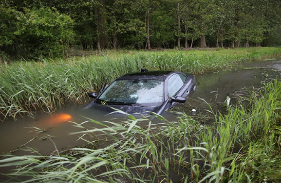 Agent haalt nat pak bij auto te water langs A2 bij Culemborg