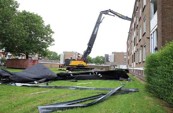 Opruimwerkzaamheden bij flat met weggewaaide dak in Tiel