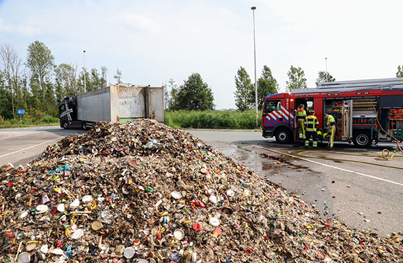 Vrachtwagen lost lading plastic op parkeerplaats om brand te voorkomen