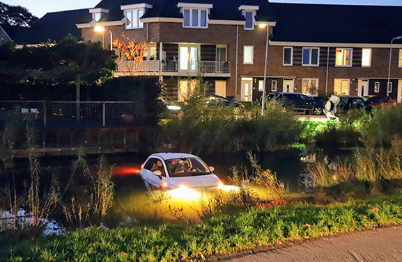 Auto rolt oprit van woning af en belandt in het water